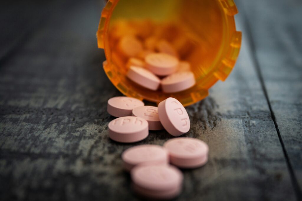 Pill bottle of prescription drugs spilled out on the counter.